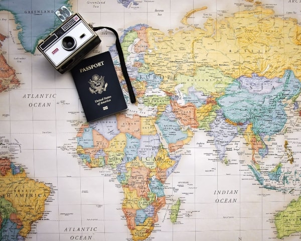 Travel page with world map with camera and passport