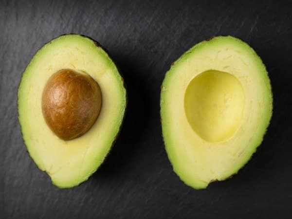 An avocado, a nutrient-dense food, cut in half