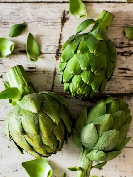 whole artichokes on a wooden table