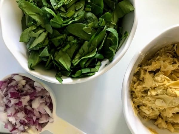spinach, chopped red onions, and chopped artichoke hearts in separate bowls