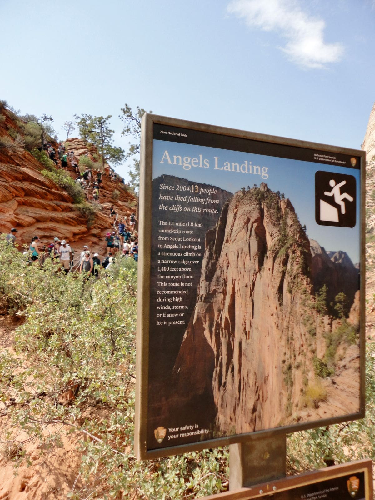 people hiking up steep trail of Angels Landing with picture of sign describing Angels Landing