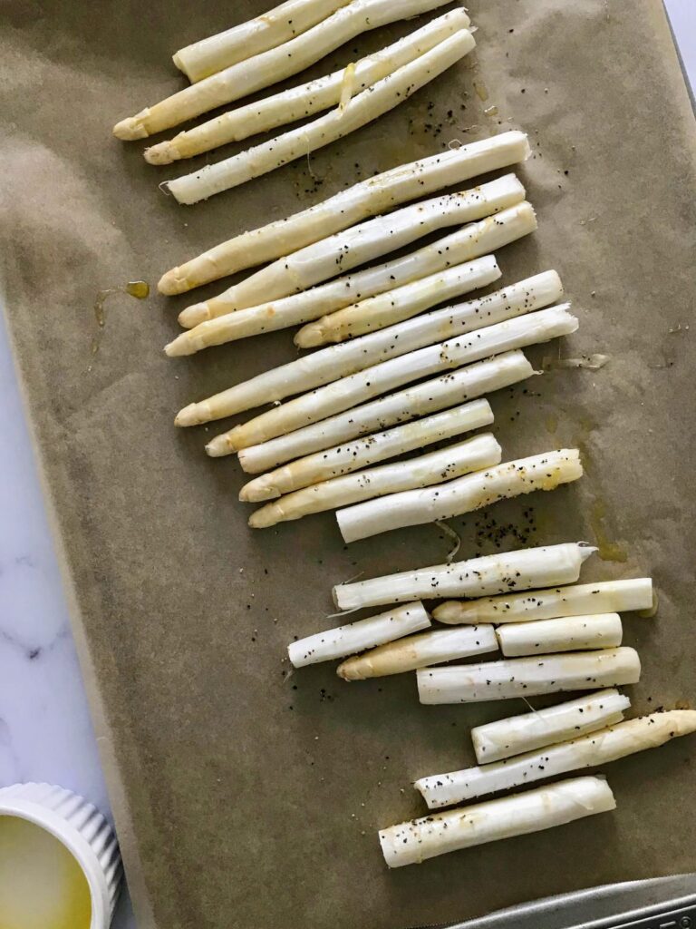 white asparagus on a sheet pan covered with parchment paper