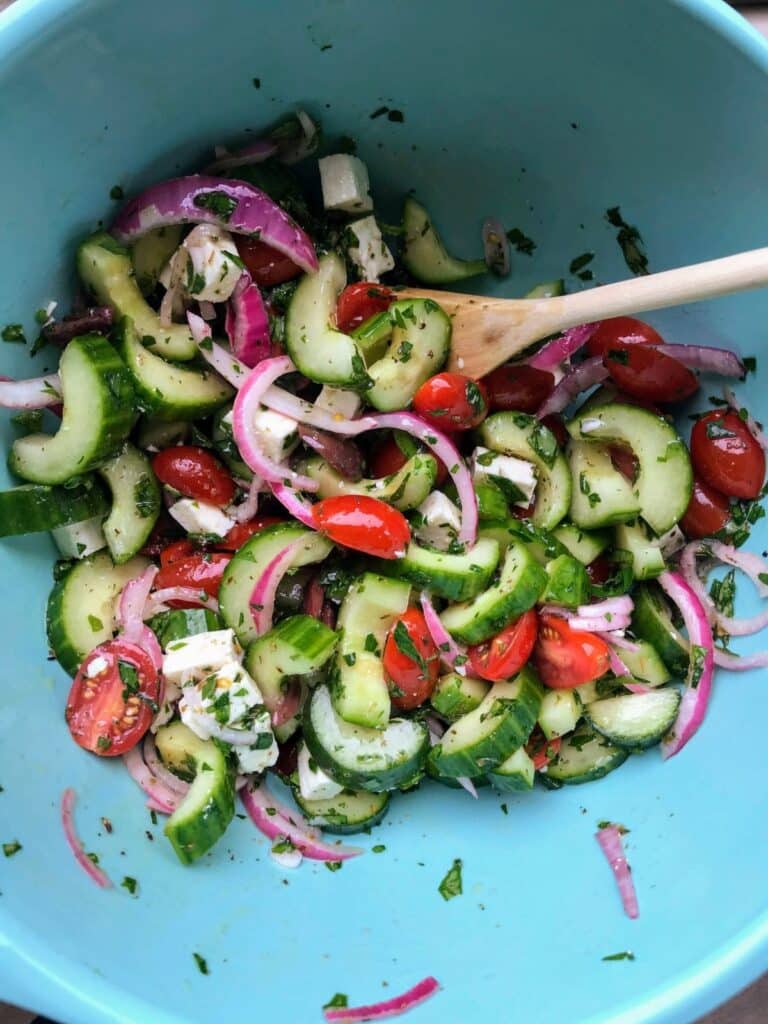 mix together cucumbers, red onions, grape tomatoes, feta cheese, and herbs in a bowl.