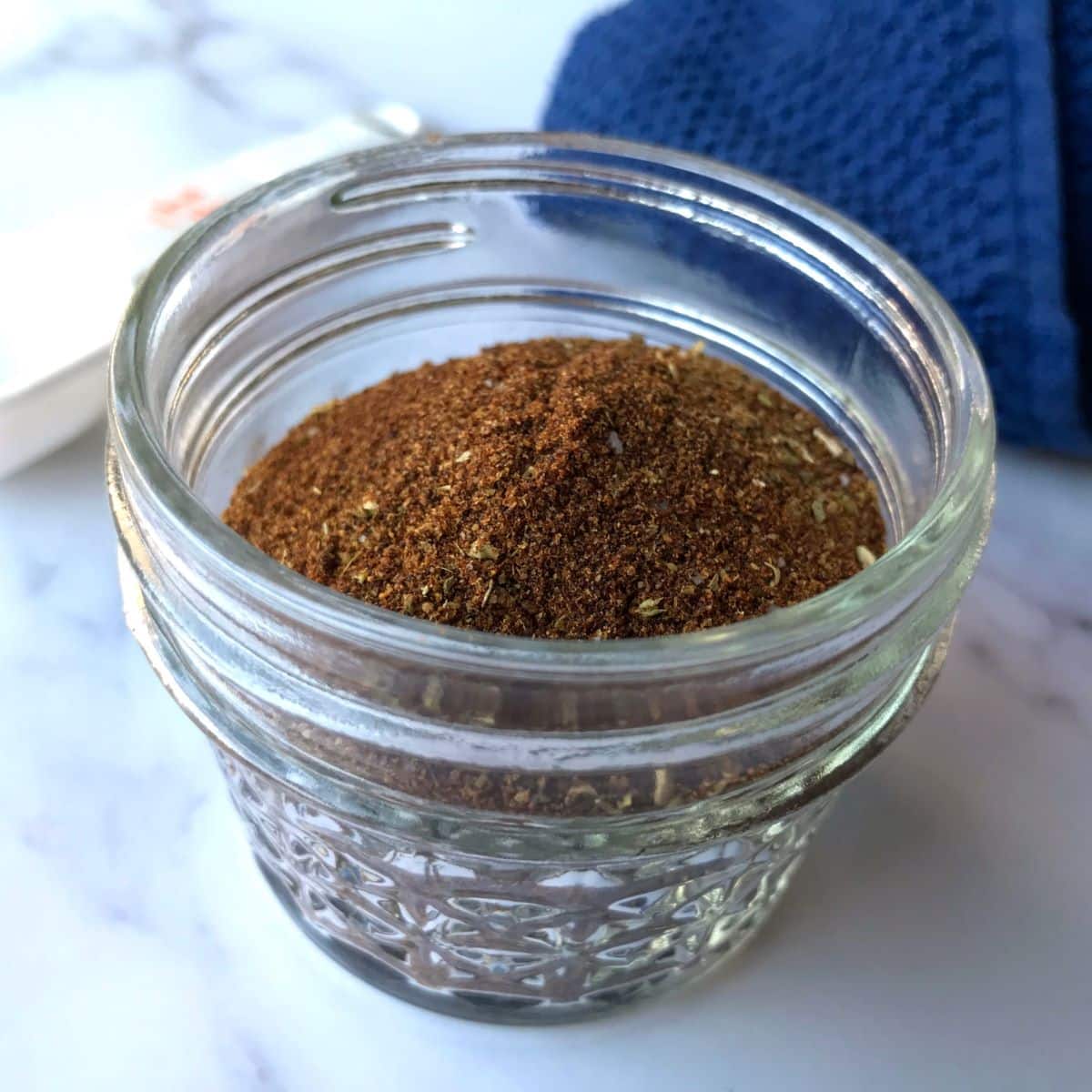 Low FODMAP taco seasoning in a small glass mason jar.